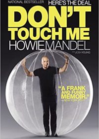 Cover of Howie Mandel's novel, "Here's The Deal: Don't Touch Me." Bright yellow capitlazied font includes a photo of Howie Mandel in a transparent ball.