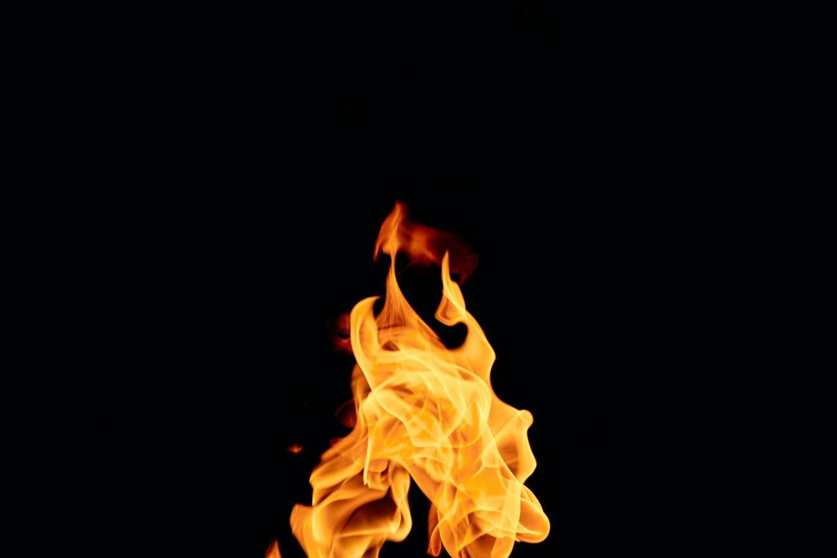 A fire burns in the center of a black background.