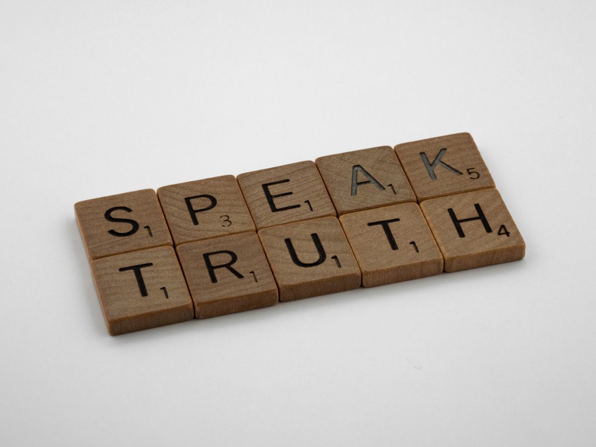 Wooden tiles with letters spell out the words "SPEAK TRUTH."