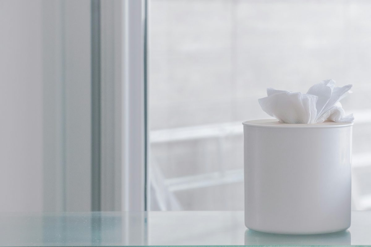 A white box of tissues sits on a white table.